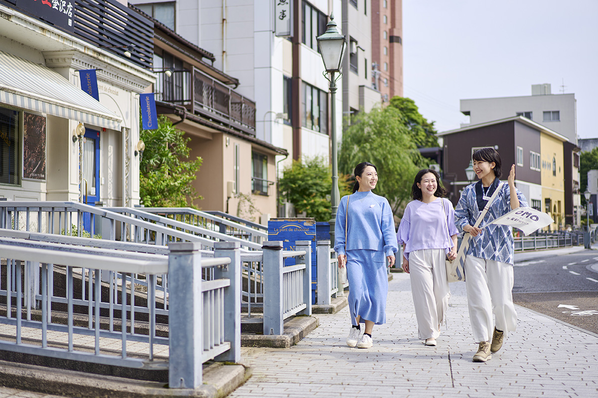 金沢片町のツアーイメージ　せせらぎ通りを歩いている人々の写真