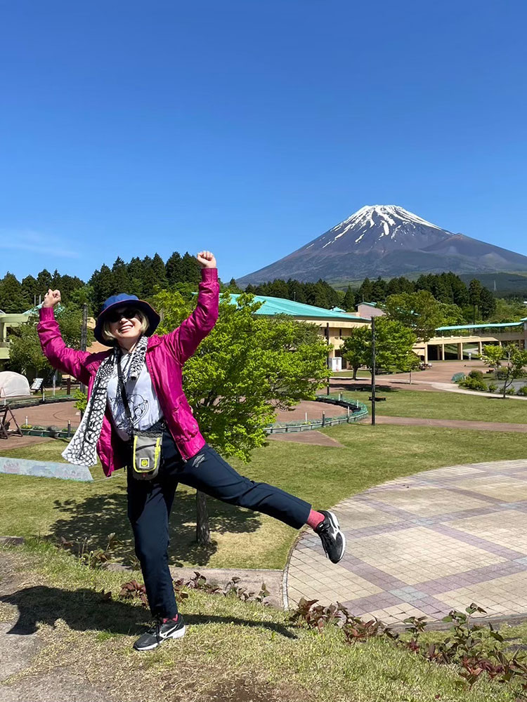 富士山をバックにはしゃぐ女性