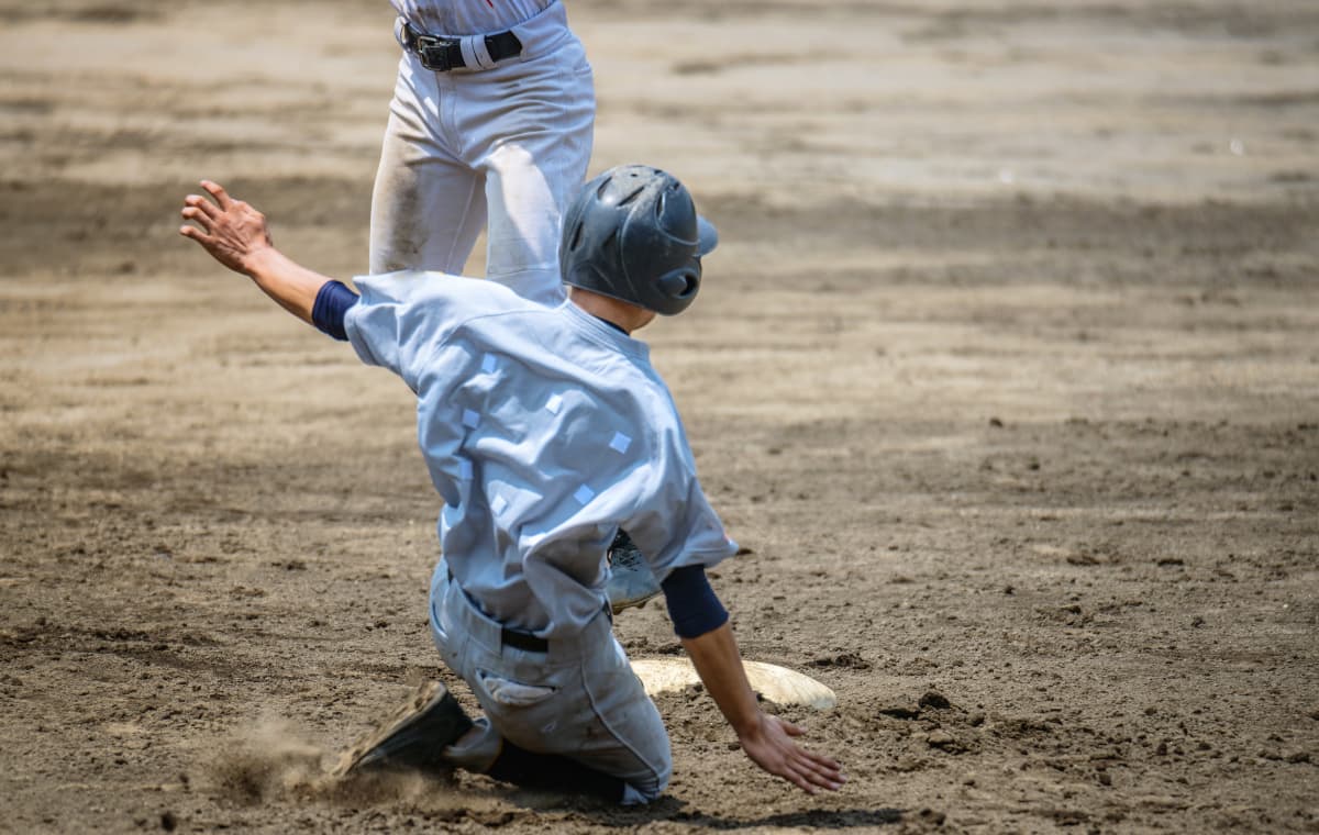 盗塁する野球少年の写真