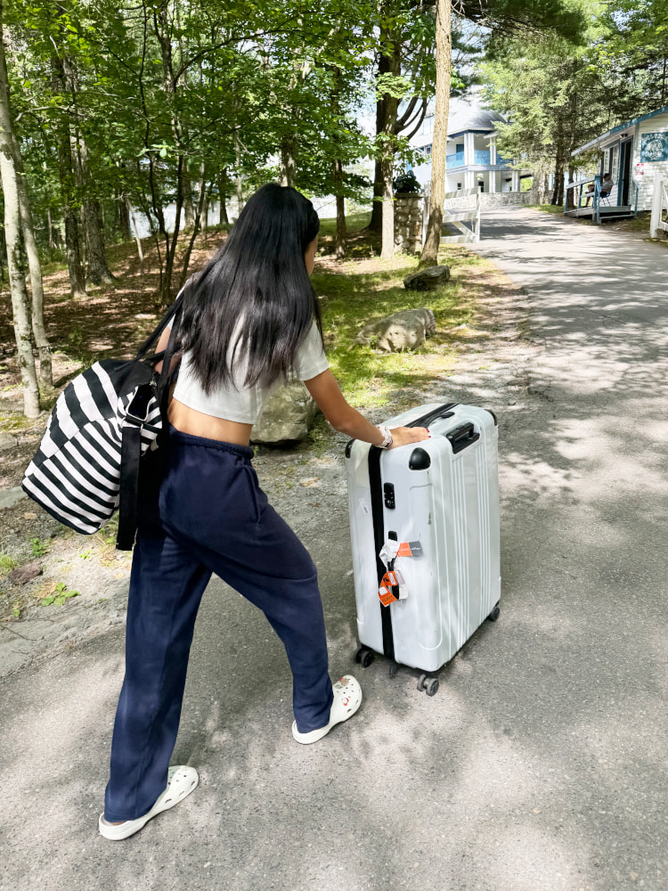 スーツケースを押す少女の後ろ姿の写真