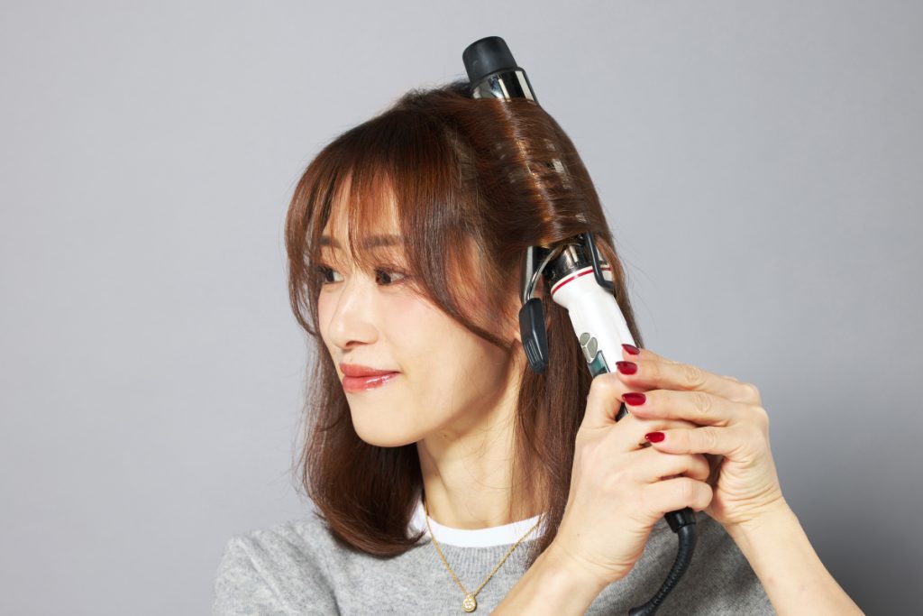 コテで顔周りの髪を巻く