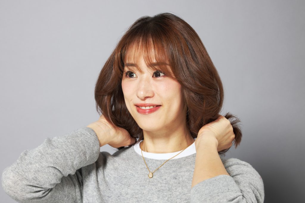 毛先にヘアオイルを揉み込む