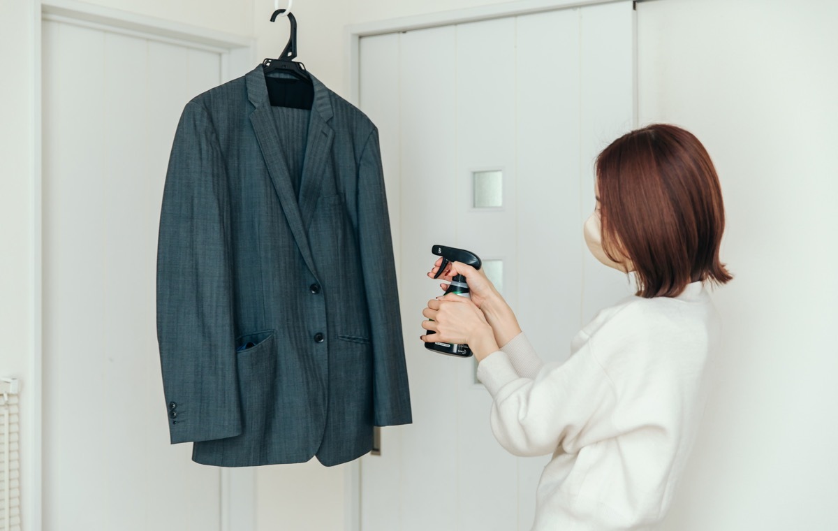 スーツにスプレーする女性