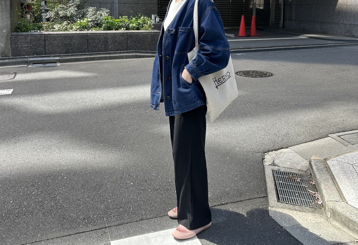デニムジャケット×黒パンツの足元にスニーカーを履いている写真