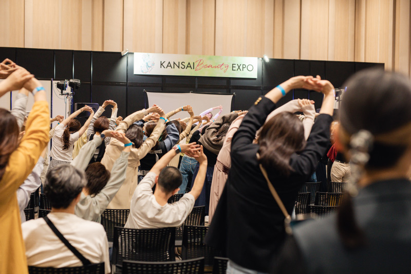 「KANSAI BEAUTY EXPO」2024開催の様子 伸びをしている人々の後ろ姿