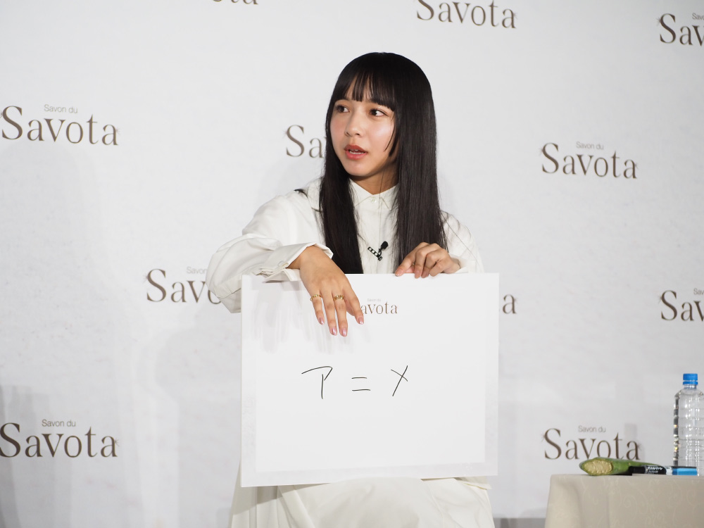 「アニメ」と書かれたフリップを持つ山之内さん