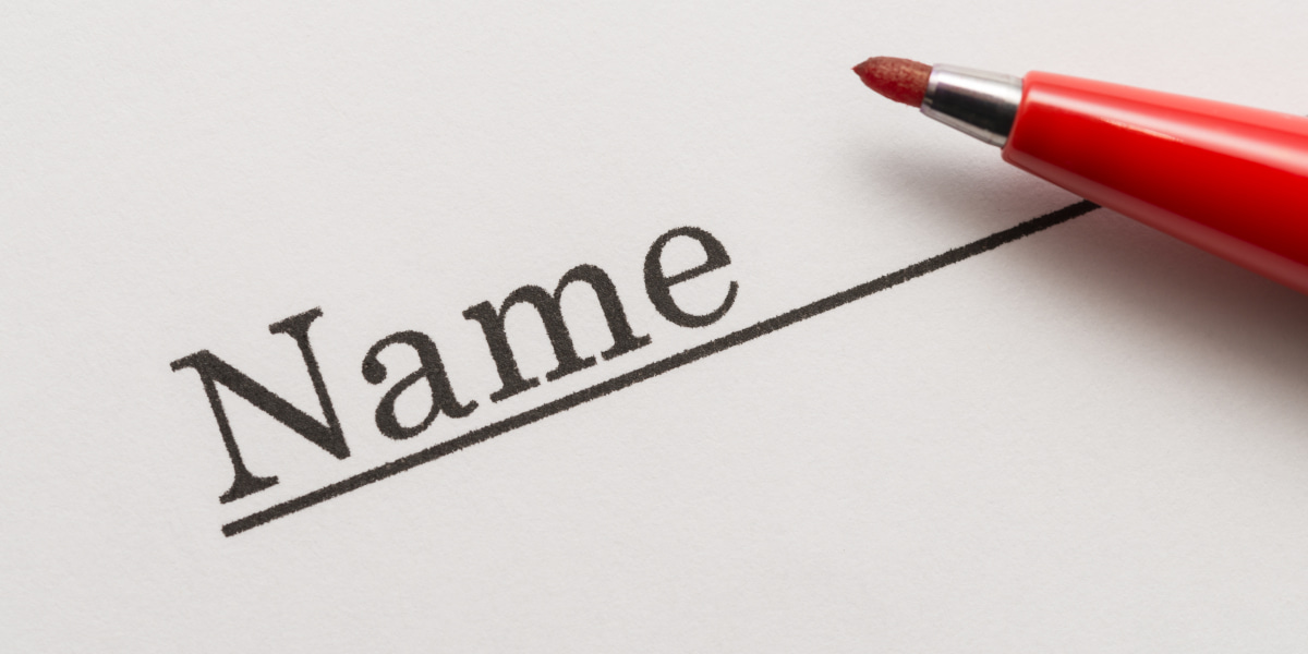 紙にNAMEと書かれている写真。赤いペンが置かれている