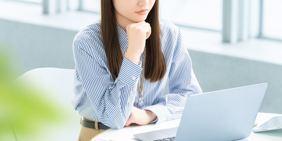 PCを眺めて悩んでいる女性の写真