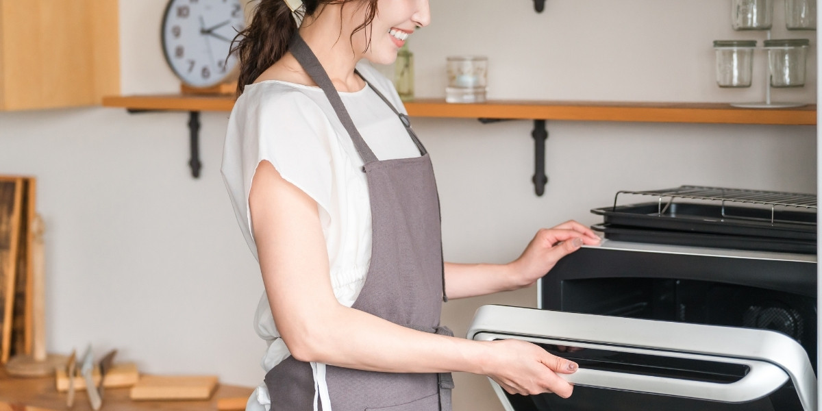 楽しそうにお菓子を作っているエプロン姿の女性の写真