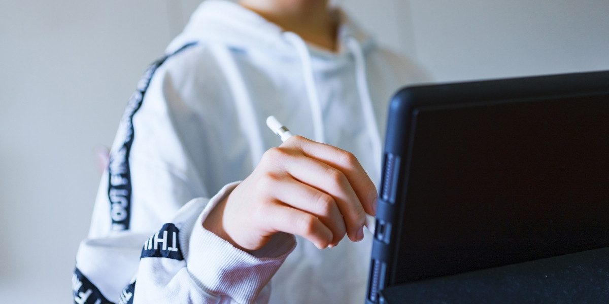 タブレットにペンで書き込む小学生くらいの子どもの写真