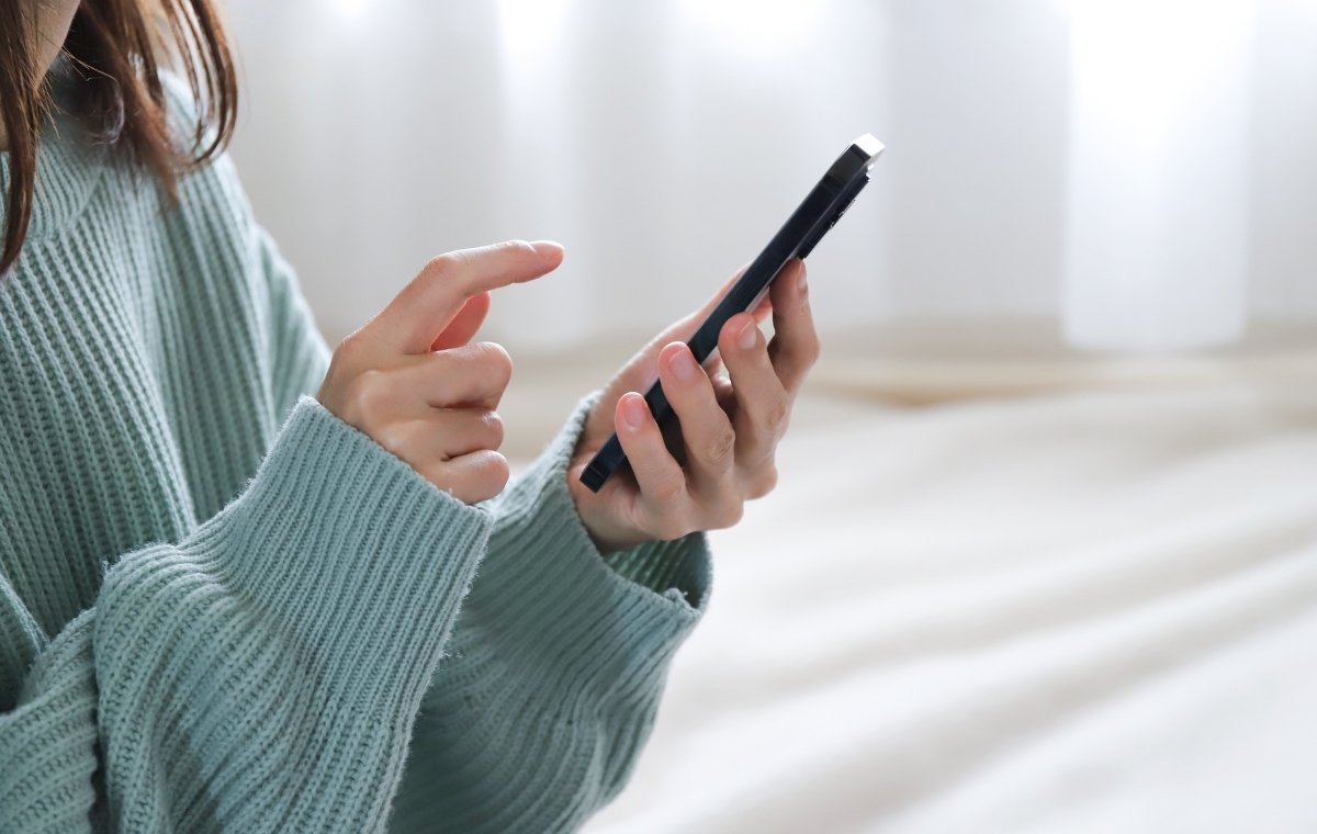 スマホをタップしている女性の写真