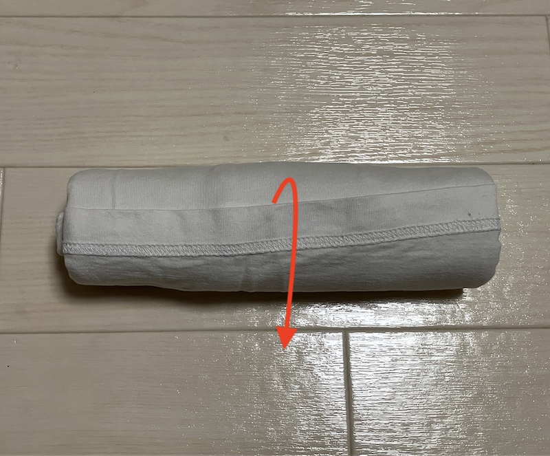 丸めたTシャツの裾を入れ込んでいる工程