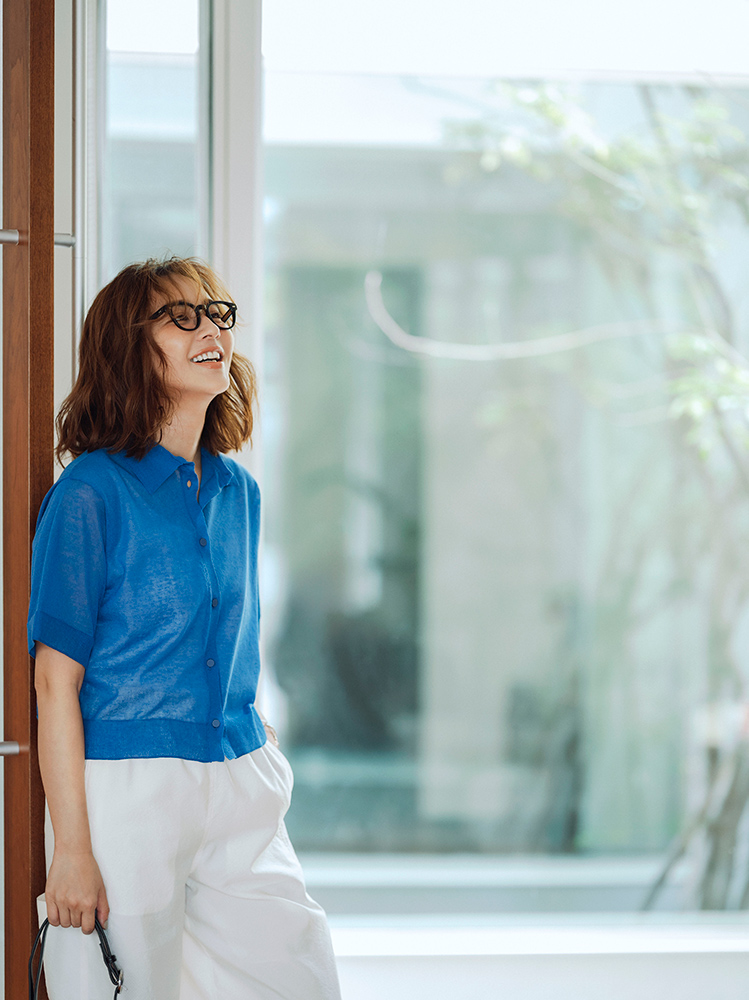 ブルーのシアーニットポロと白イージーパンツのきれいめカジュアルコーデ