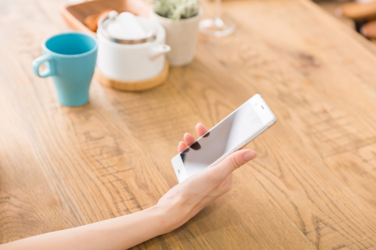 スマホを持った女性の手元の写真