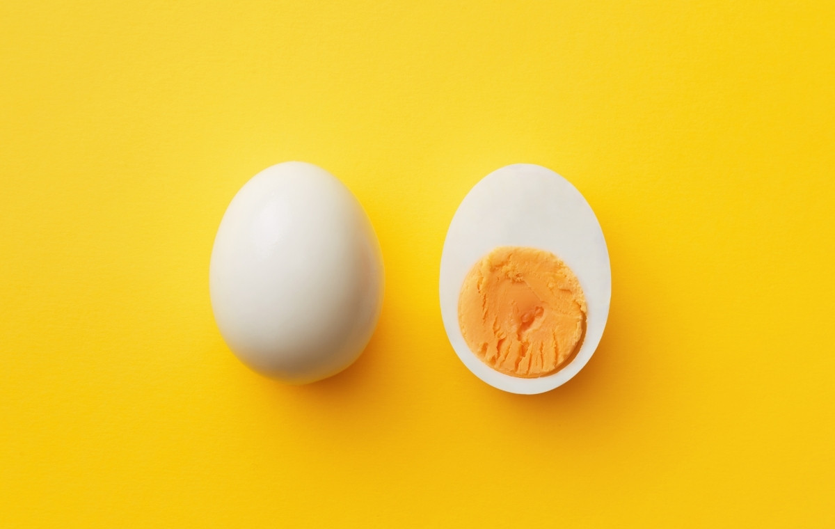 黄色い背景に1/2にカットされたゆで卵が置かれている写真