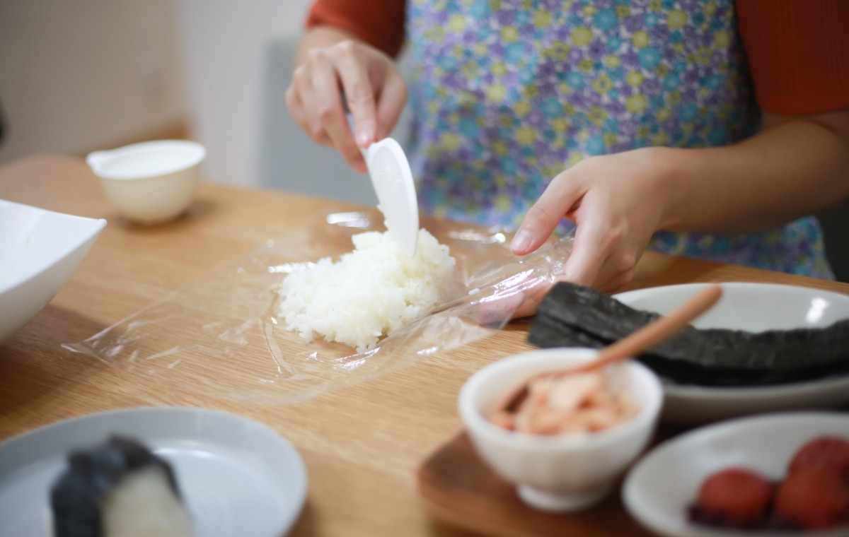 おにぎりを握る女性の写真