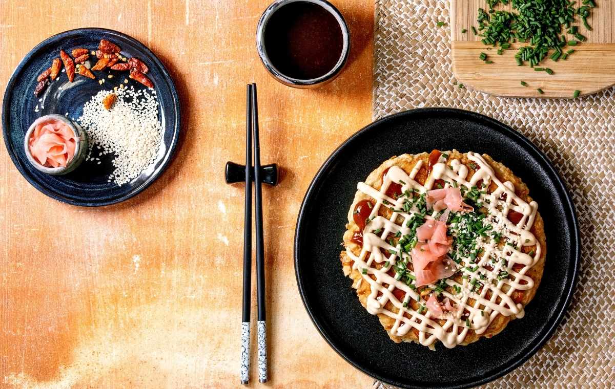 お好み焼きとお箸、薬味が並んだテーブルの写真