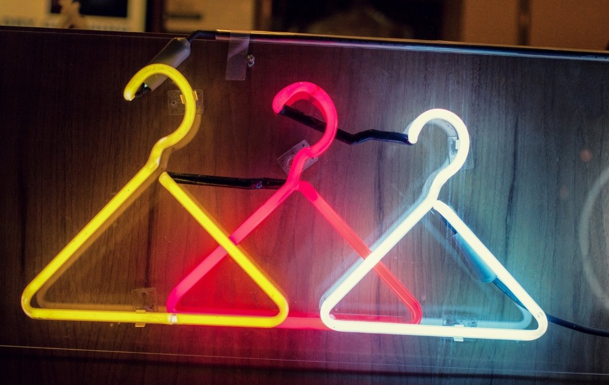 ハンガーを模した黄色・赤・白の3色のネオンが光っている写真