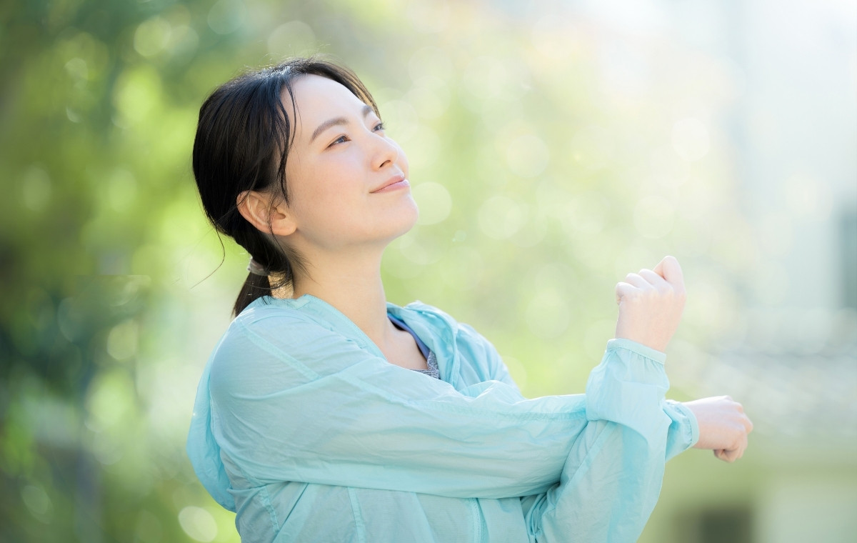 シャカシャカ素材のジャージで準備運動している女性の写真