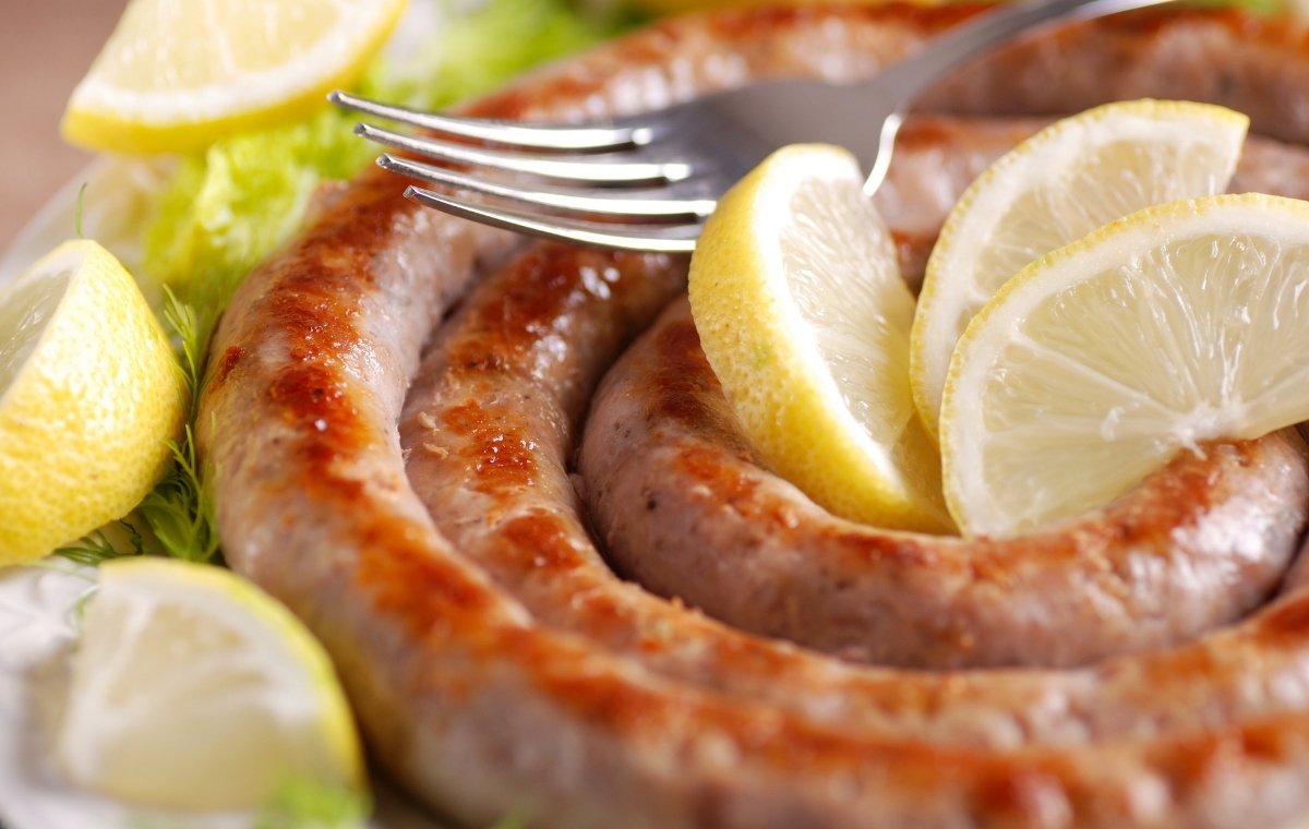 渦巻状の焼かれたサルシッチャとレモンの写真