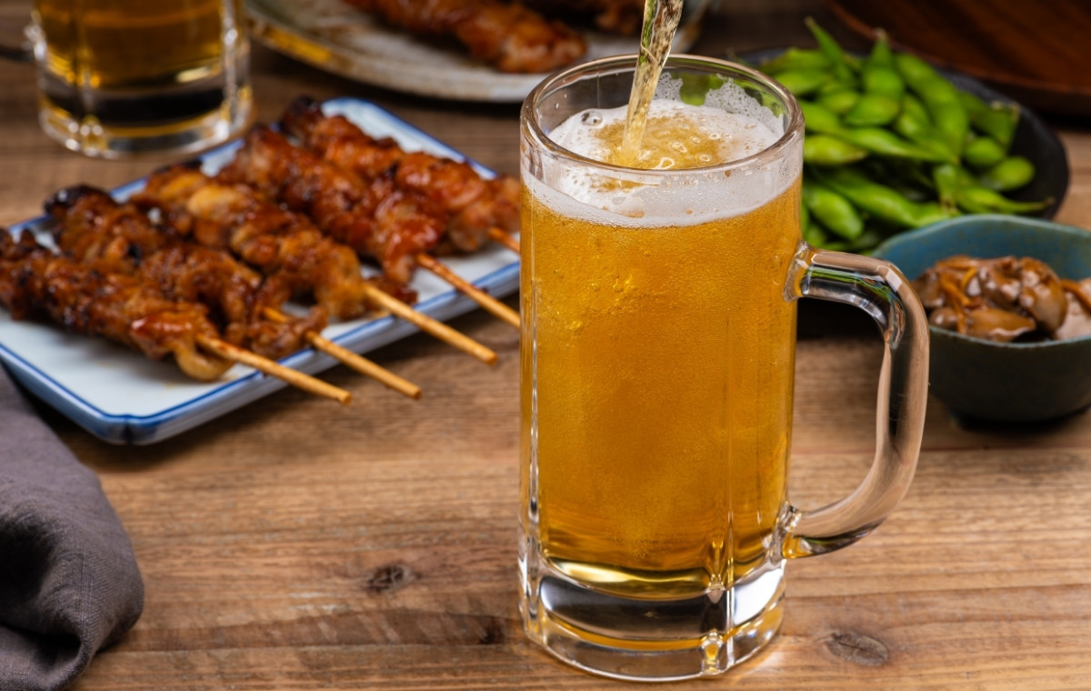 焼き鳥と枝豆と注がれているビールの写真