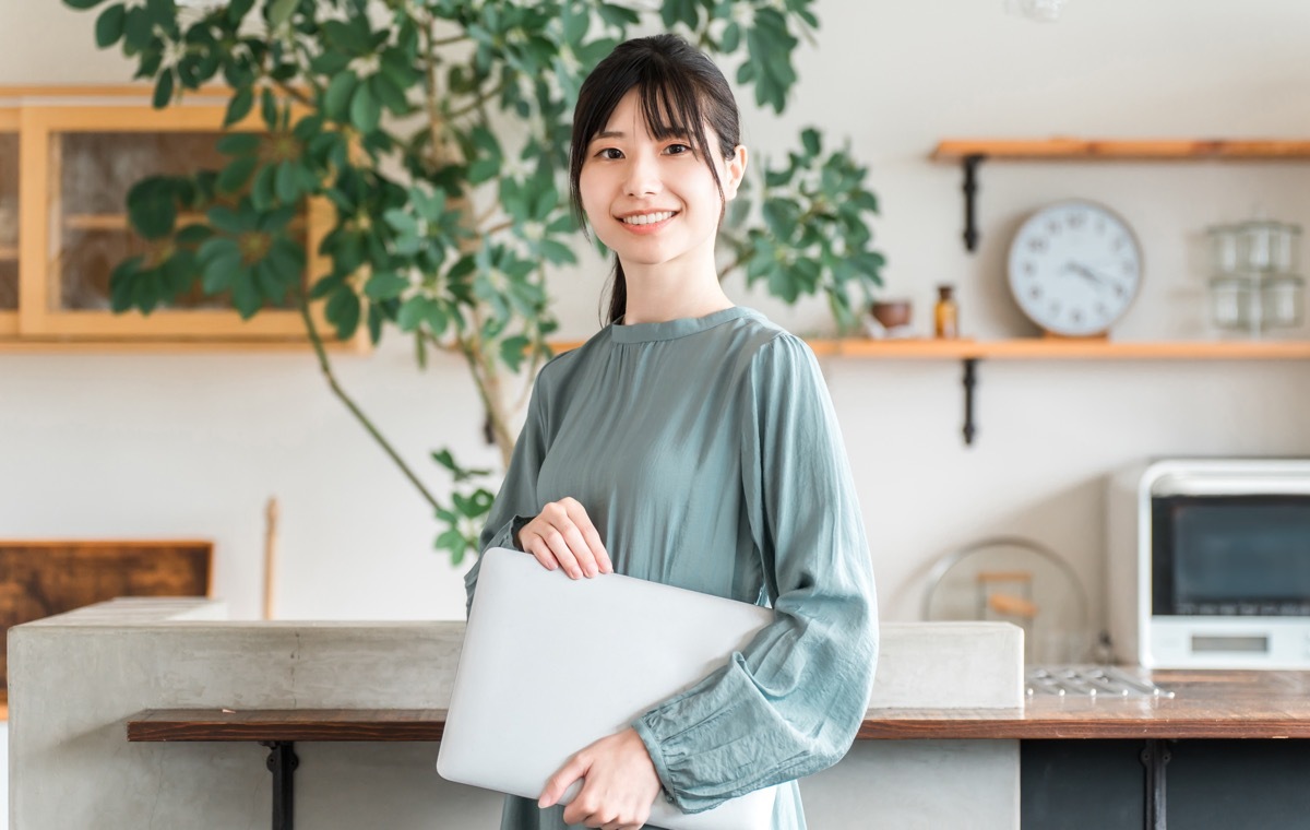 笑顔でパソコン抱える女性