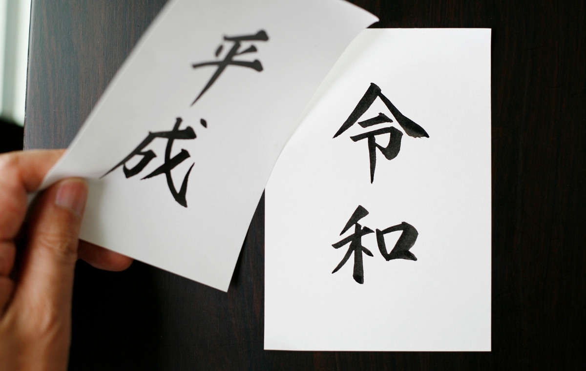 平成と書かれた紙をめくったら令和と書かれた紙が現れている写真