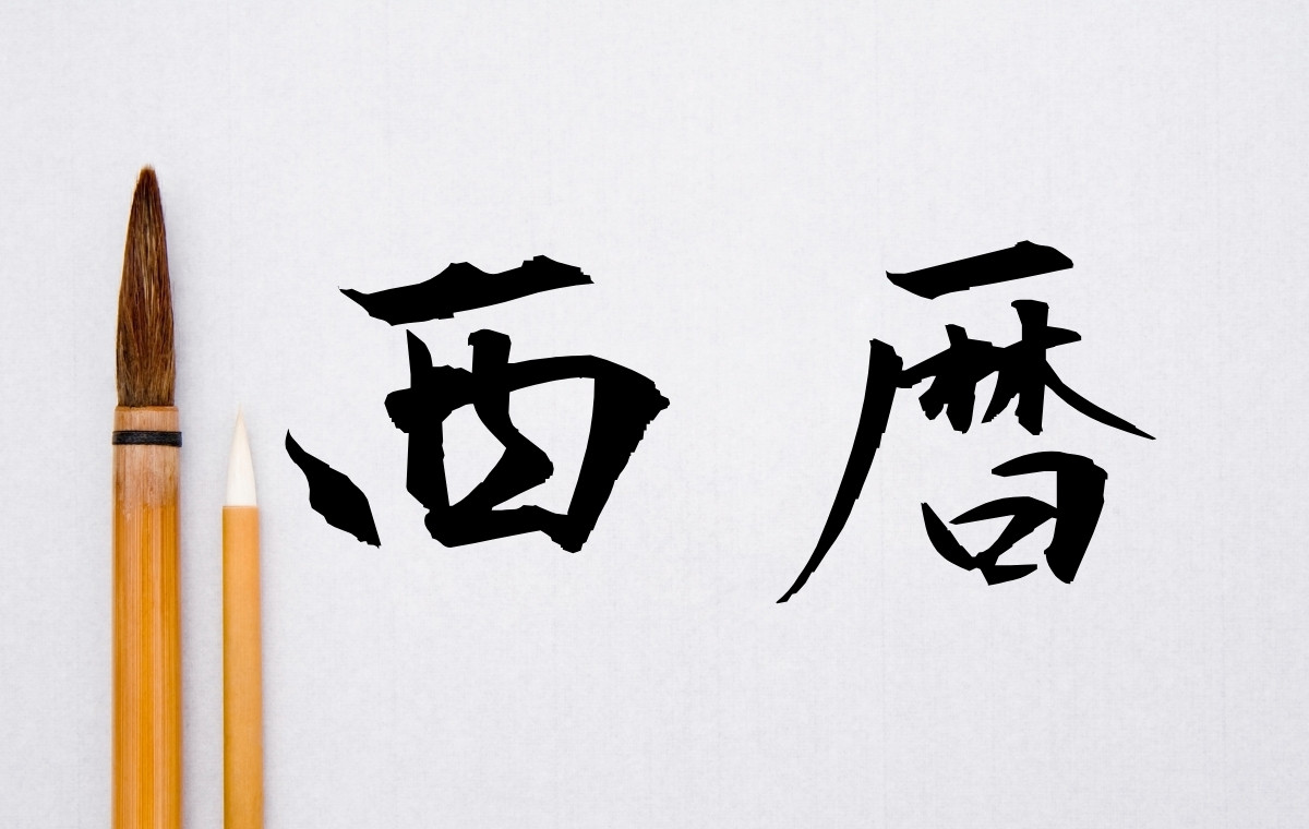 筆と半紙の写真。筆文字で西暦と書かれている