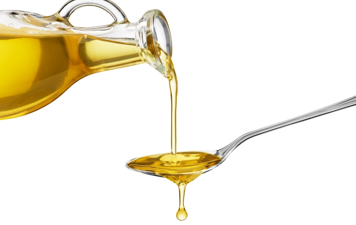 オイル差しからスプーンに油を注いでいる写真