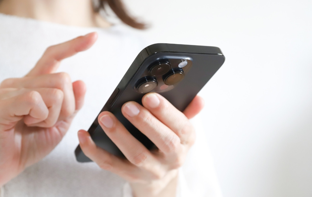 iPhoneを操作する女性の手元の写真