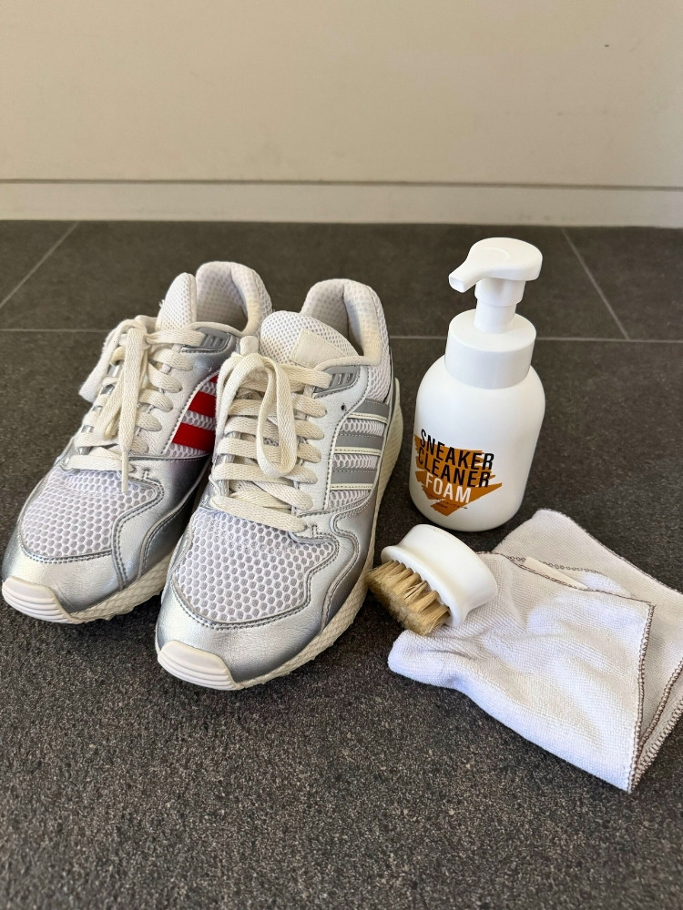 スニーカーとクリーナー、ブラシとふきんの写真