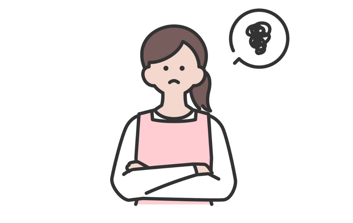 腕を組んでモヤモヤしている様子のエプロン姿の女性のイラスト