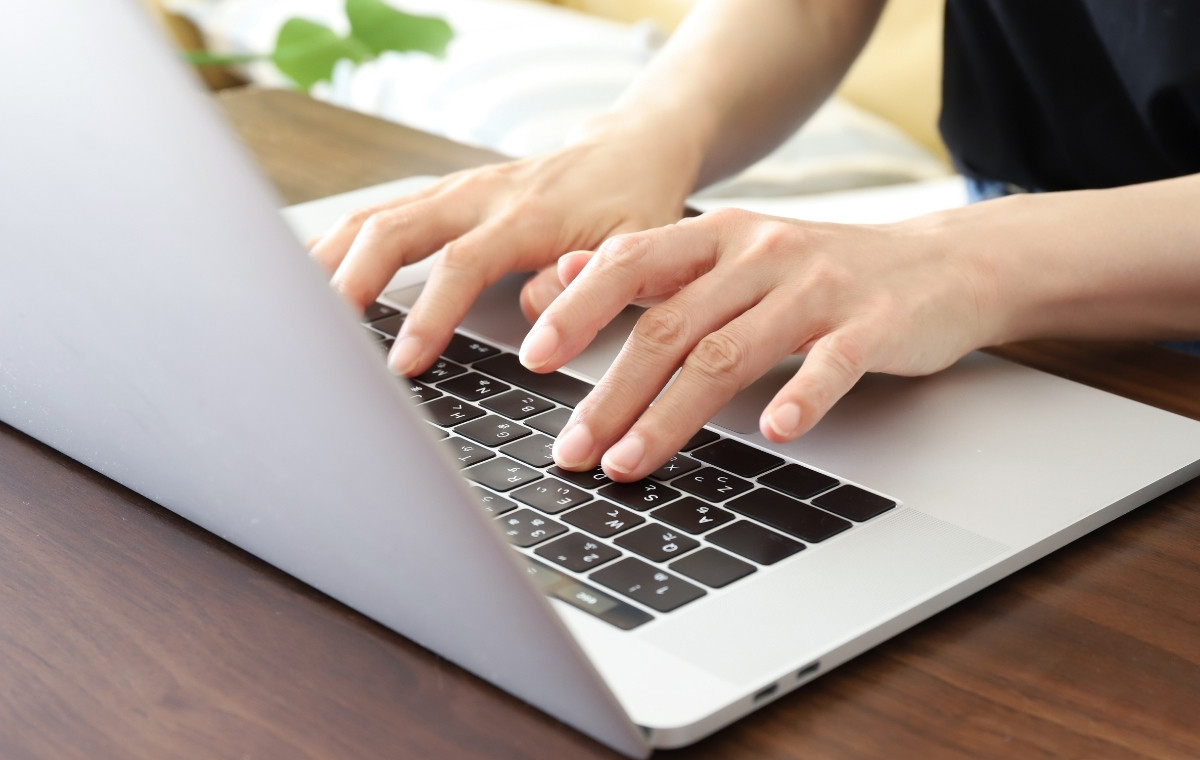 ノートパソコンを操作している手元の写真