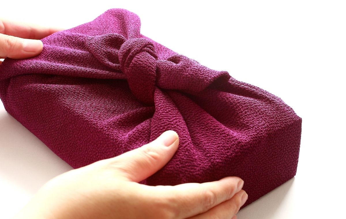 風呂敷に包まれた品物に手を添えている写真