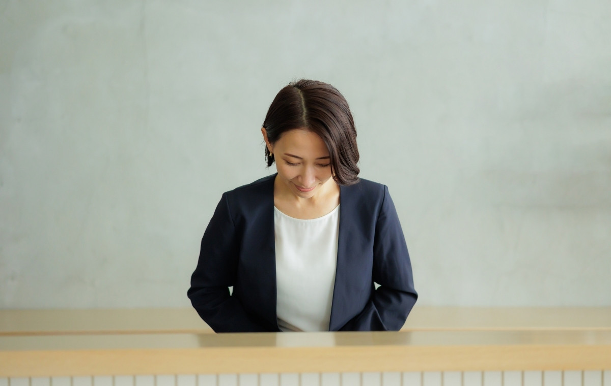 お辞儀しているビジネスウーマンの写真