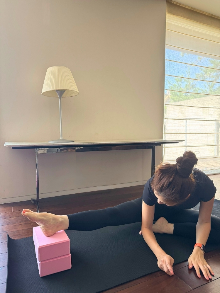 2個重ねたブロックに伸ばした足のかかとを載せている写真
