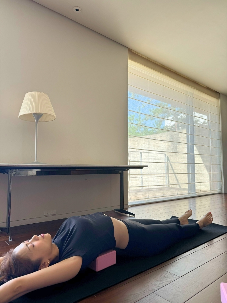 ブロックの上に寝て、腕を伸ばしている写真