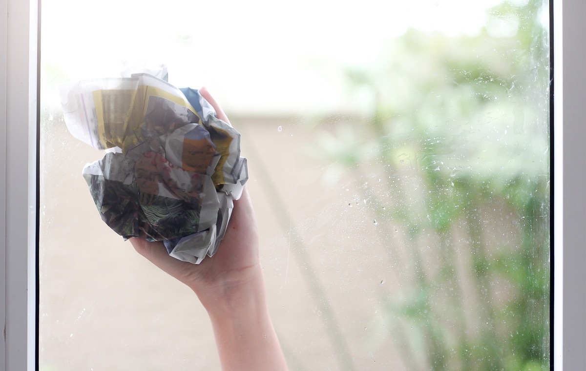 新聞紙で窓を拭く手