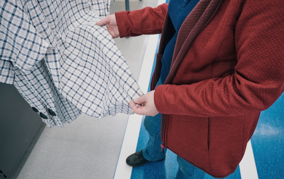 チュニックを手にとる女性