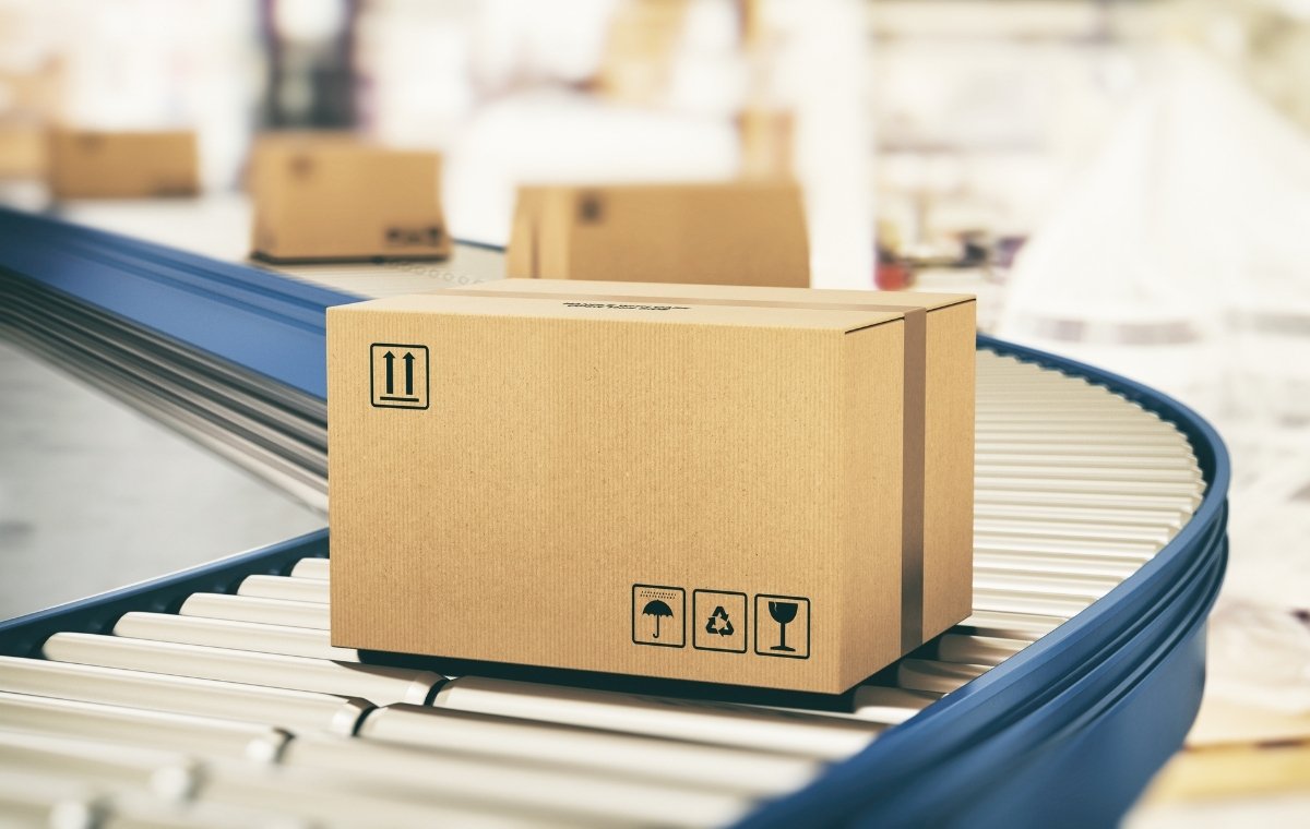段ボールがコンベアで運ばれている写真