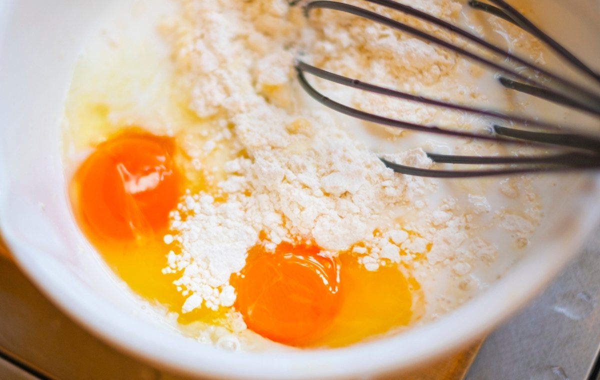 卵と小麦粉をボウルで混ぜている写真