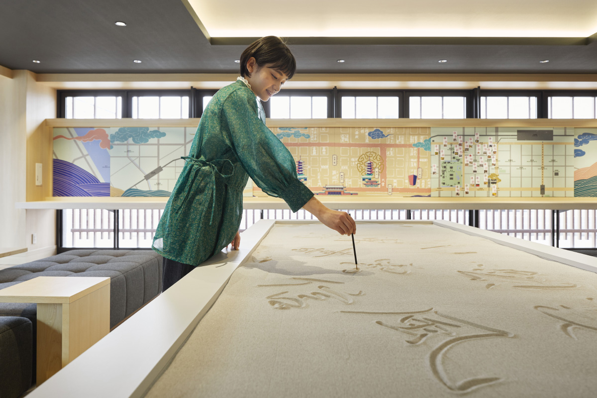 砂で文字を書いている人