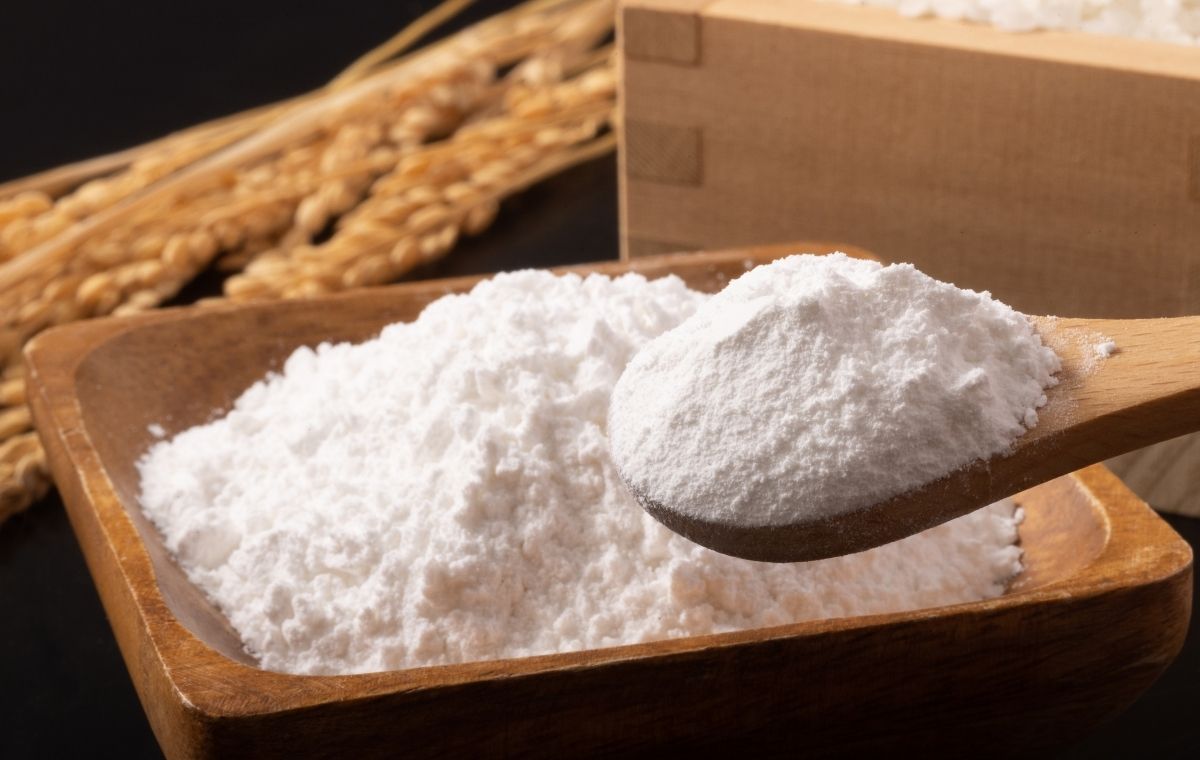 稲穂と升に入った白いもち粉の写真