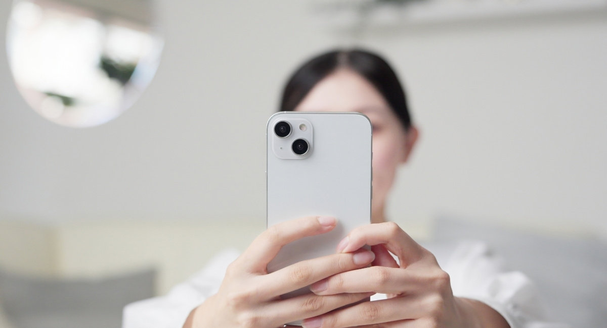 スマホで顔写真を撮影している女性の写真