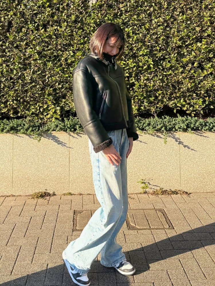 フェイクレザージャケット×ライトブルーデニム×スニーカーコーデの写真