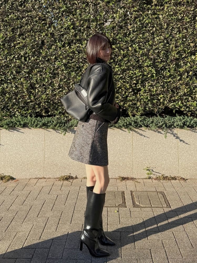 フェイクレザージャケット×ショートパンツ×ロングブーツコーデの写真