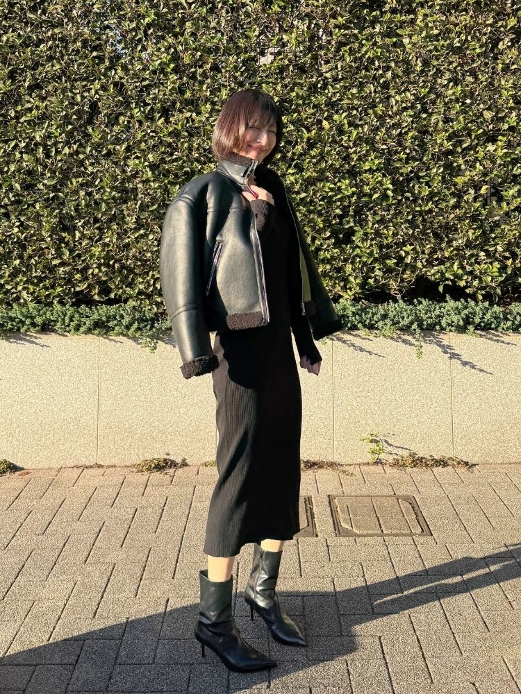 フェイクレザージャケット×黒ワンピ×黒ショートブーツコーデの写真