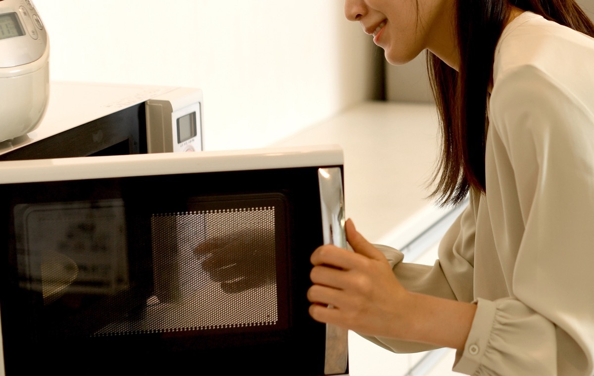 レンジを開ける女性
