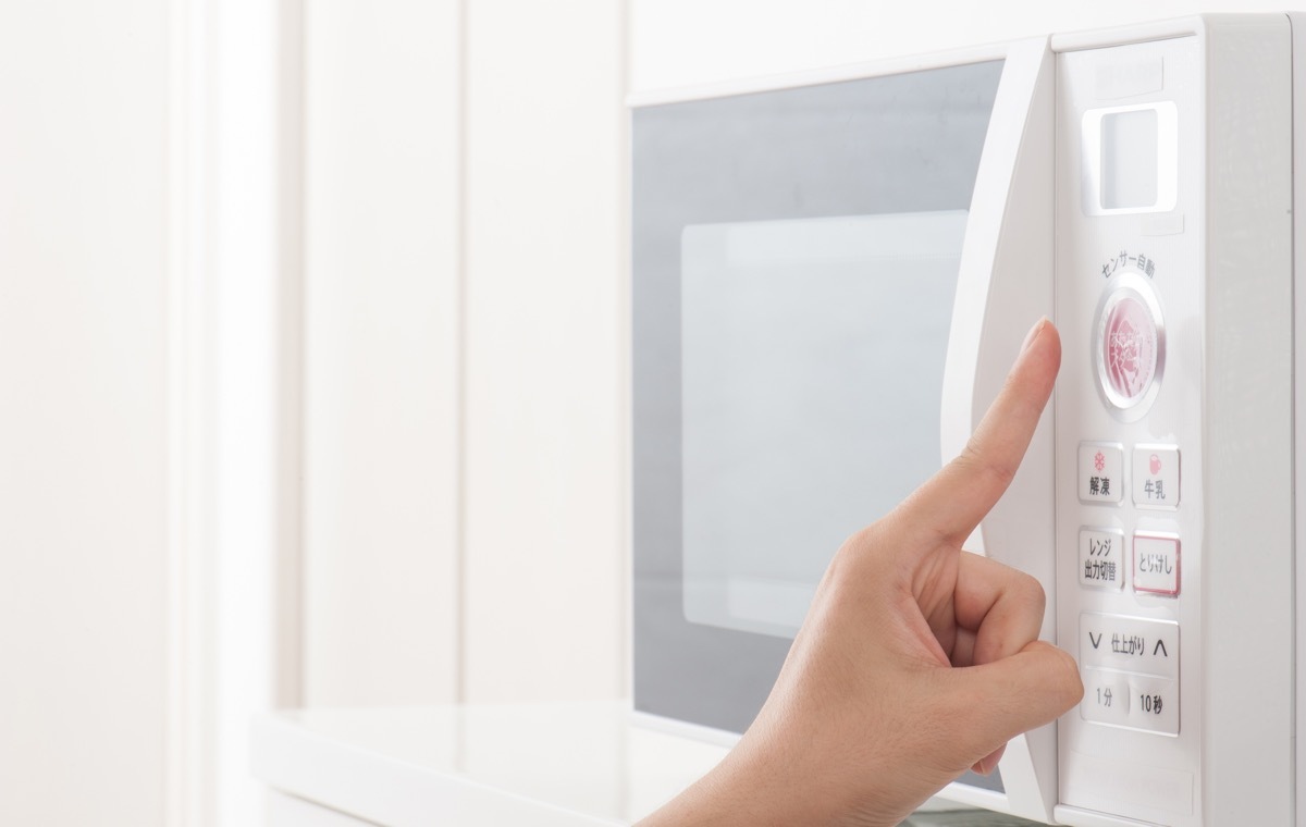 電子レンジを押す指