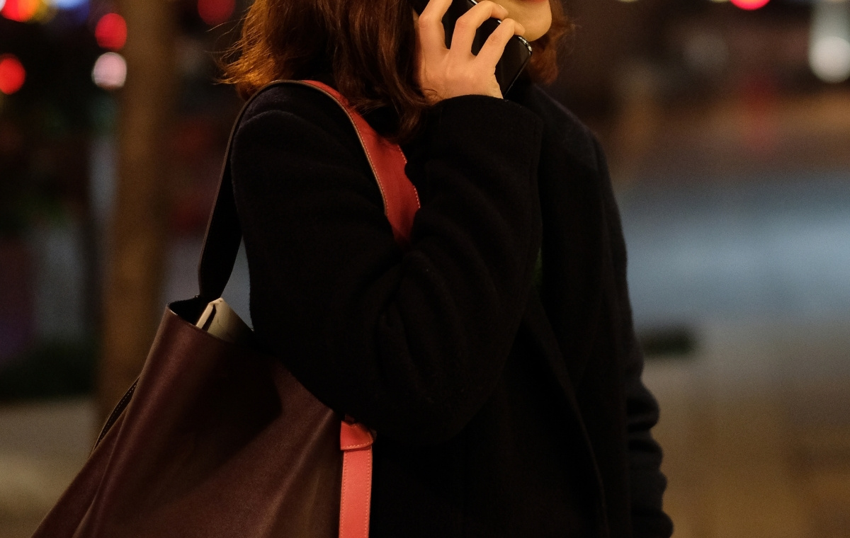 夜道にスマホで電話している女性の写真